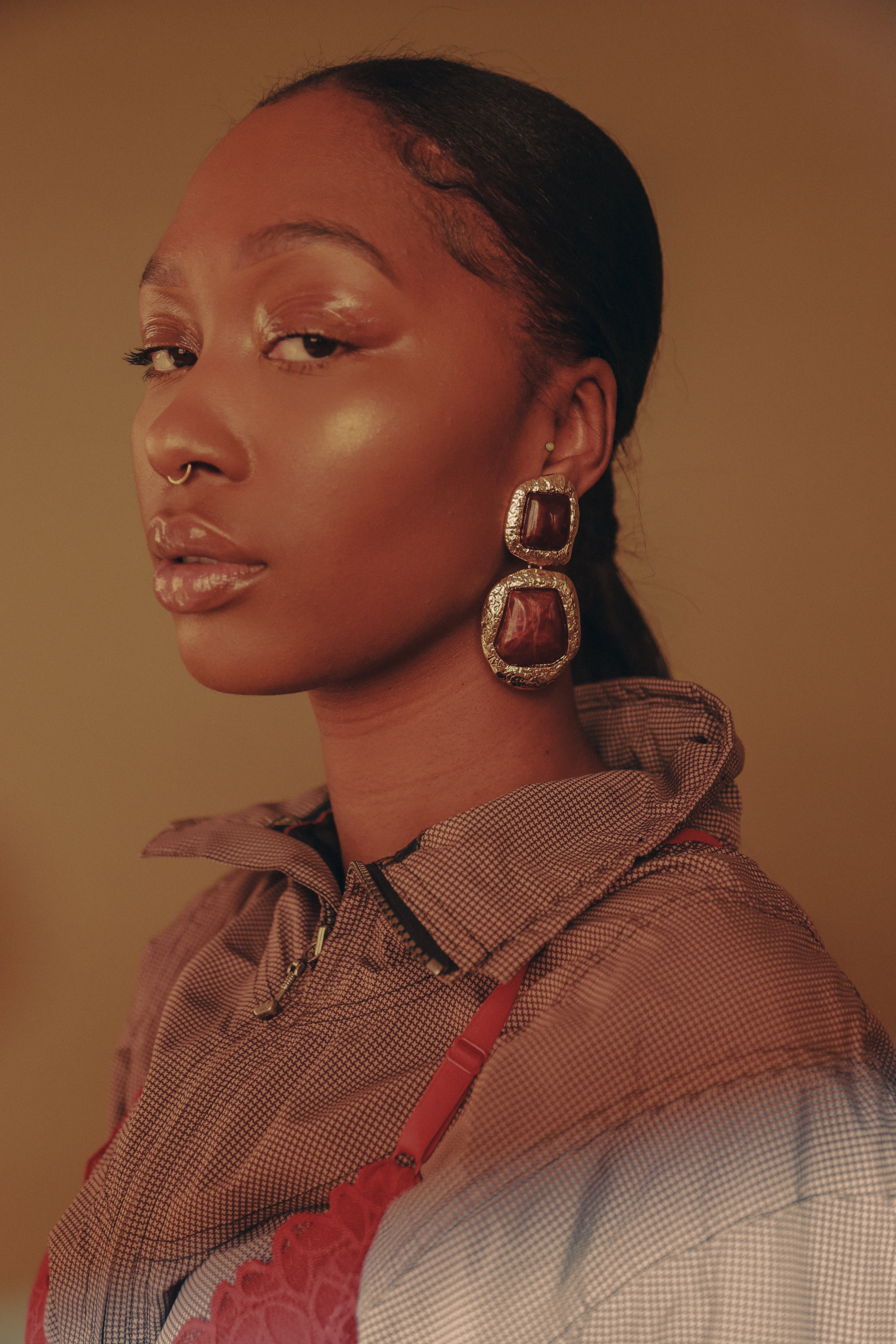 Black woman with nose ring and statement earrings by Bree Holt